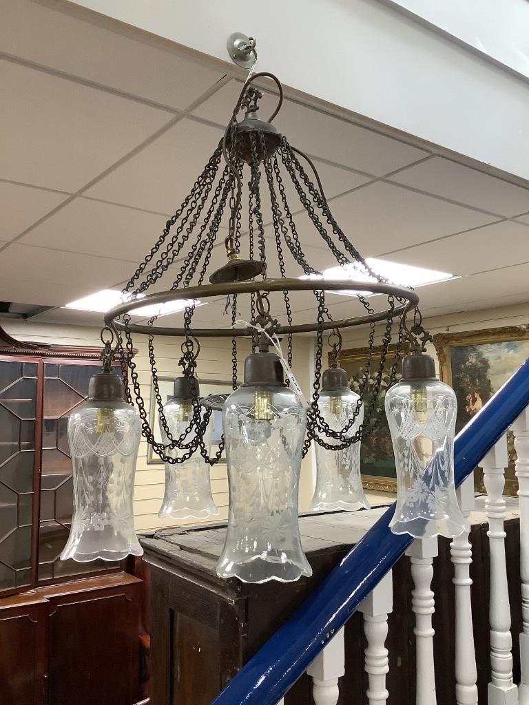 A brass five-light chandelier with etched glass pendant shades